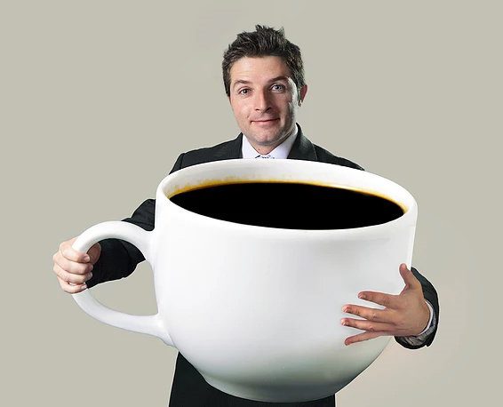man holding a huge coffe glass